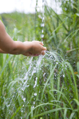 A child is washing his hands outside.の写真素材
