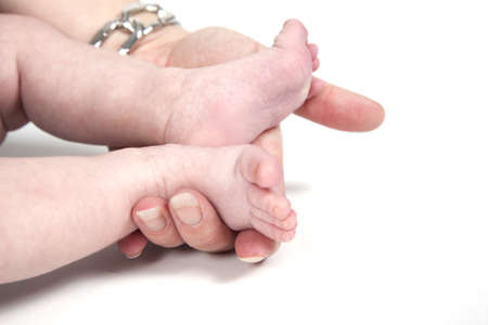 Mother is holding the feet of her baby.の写真素材