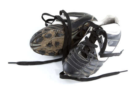Muddy football shoes on a white background.の写真素材