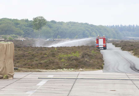 A fire truck in action in the open field.