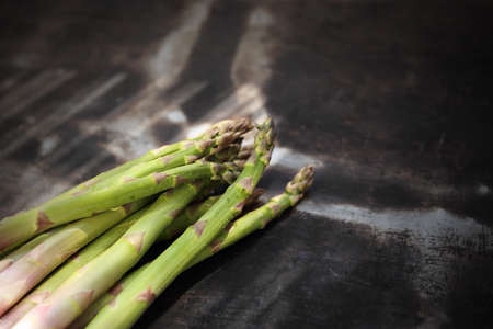 Composition of fresh green asparagus on a dark background, horizontal composition with space for text.の写真素材