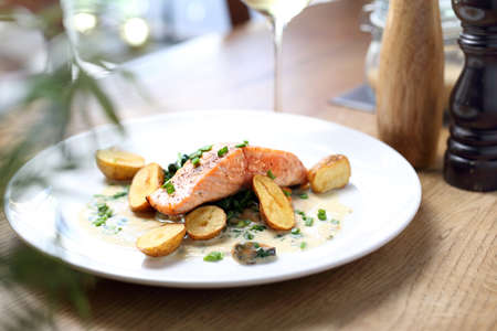 Elegant, exquisite dinner dish served on white plates with a glass of wine. Proposal proposal, menu. Horizontal compositionの写真素材