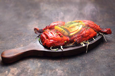 Appetizing spicy dish. Red chicken baked in a colorful marinade.の写真素材