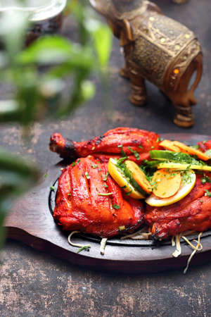 Appetizing spicy dish. Red chicken baked in a colorful marinade.の写真素材