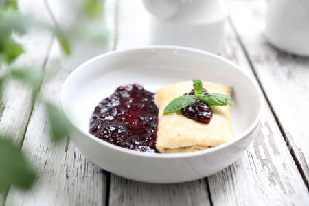 Appetite dish. Homemade sweet pancakes, served with cheese stuffing and sweet fruit jam.の写真素材