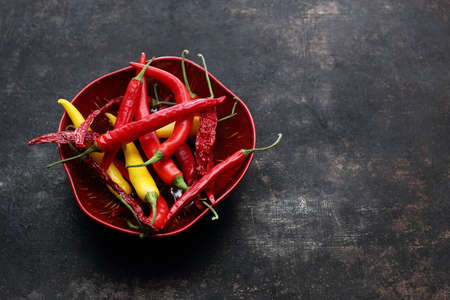 Red and yellow chillies on a black background