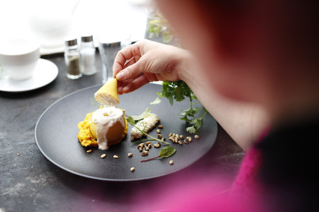 Pear with goat cheese on pumpkin puree. An elegant gourmet dish served on a black plate. A proposal for an application. Culinary photographyの写真素材