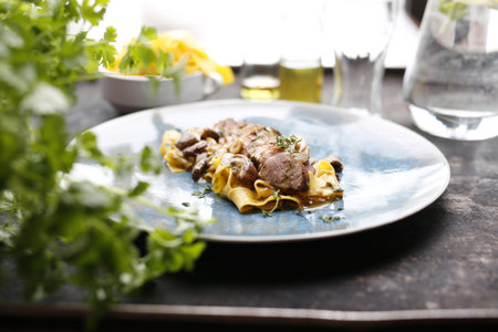 Tagliatelle pasta with sirloin and mushroom sauce. Food, an appetizing dish on a plate. A proposal for an application. Culinary photography.の写真素材