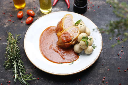 Stuffed cabbage with minced meat in tomato sauce served with potatoes. Ready dish served on a plate. Serving proposal, culinary photography.の写真素材
