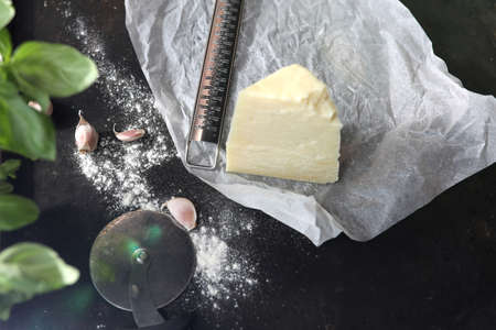 Parmesan cheese and ripening cheese. Cheese cube on a dark background.
