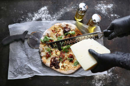 Pizza with white sauce, bacon, caramelized onion, goat cheese, and arugula. Pizza in a box. Pizza...
