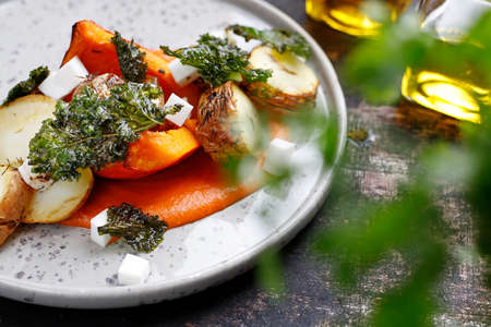 Baked vegetables on pumpkin puree. Vegetarian cooking. Culinary photography. Suggestion to serve the dish.の写真素材