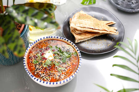 Lentil soup with tomatoes, sour cream and herbs. Vegetarian food, colorful and appetizing dishes.の写真素材