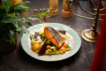 Grilled salmon on vegetables. A dish of Jewish cuisine. Culinary photography. Suggestion to serve the dish.の写真素材
