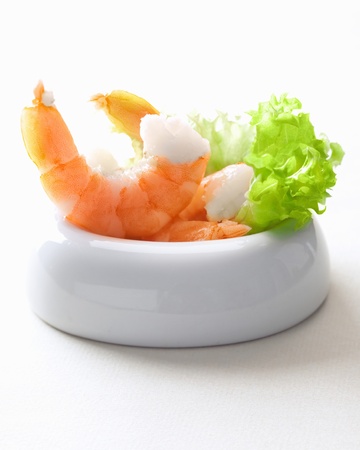 scampis in a bowl with salad on whiteの写真素材