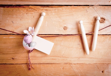 Country Easter Eggs with a blank label hanging from wooden pegs against old wooden planks.の写真素材