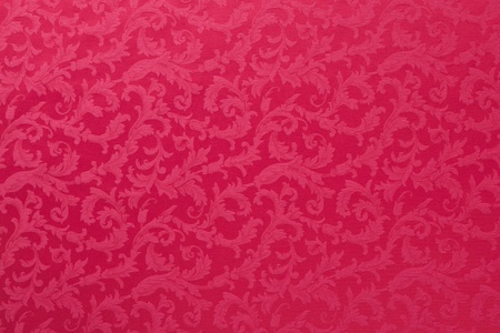 Abstract background of a heavy red brocade fabric with interwoven repeat design.の写真素材