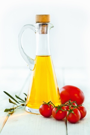 Ingredients for Italian Food, olive oil, tomatoes, fresh basil and herbs for seasoning, standing on a wooden backgroundの写真素材