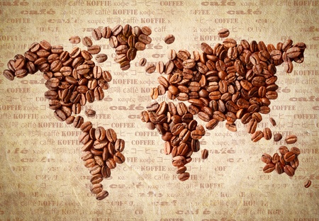 Fresh roasted coffee beans arranged in the shape of a world map on aged vintage paper with the word coffee in multiple languages.の写真素材