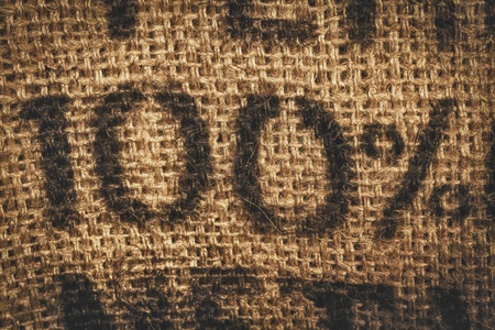 Background of woven textured hessian stamped with one hundred percent - 100 percent - in numeralsの写真素材