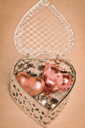 Valentines or anniversary gift of romantic hearts nestled inside a delicate silver filigree heart-shaped gift boxの写真素材