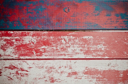 Grunge painted wooden texture background with red paint peeling off weathered timber planks with woodgrainの写真素材