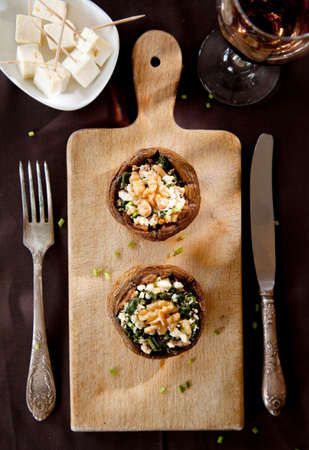 Filled mushroom with cheese on wooden breadboardの写真素材