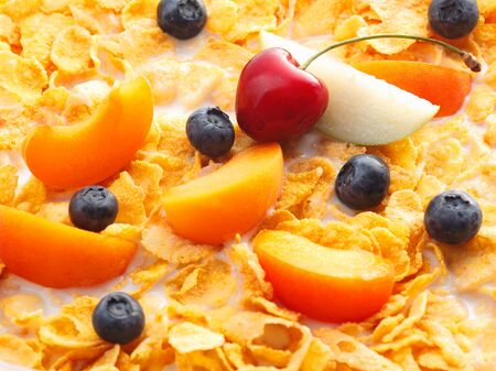 Milky fruits with cereals. Peaches, blueberries cherries and apple slices swimming in milk