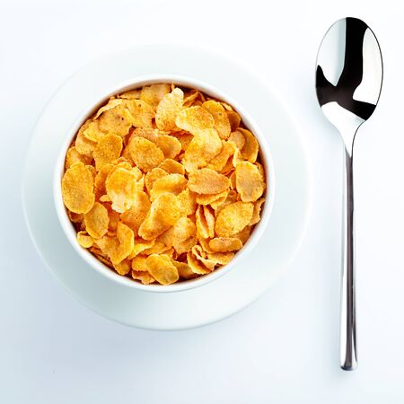 Bowl of cereal and spoon waiting for milk set on the table for a nutritious breakfast