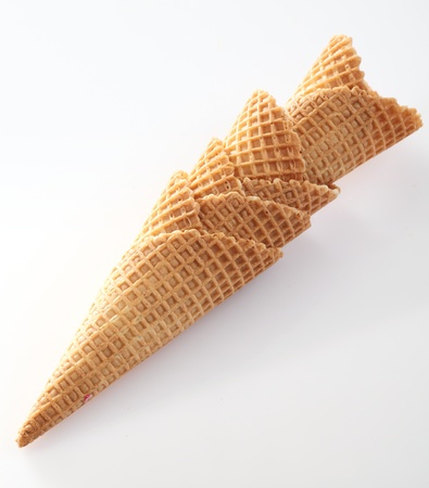 Stack of crisp golden waffle cones with the traditional indented pattern for use with icecreamの写真素材