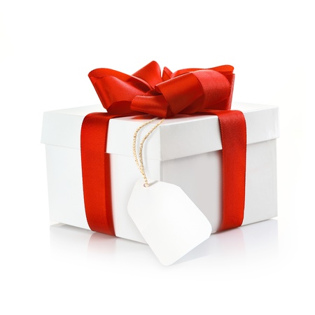 Christmas surprise gift with blank tag and a decorative red ribbon and bow on a white studio background Christmas surprise gift with blank tag and a decorative red ribbon and bow on a white studio background