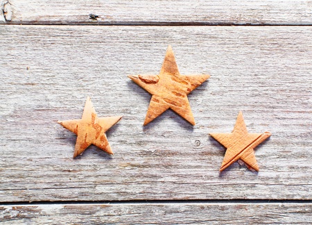 Three decorative Christmas stars on grungy weathered wooden boards with copyspaceの写真素材