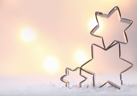 Atmospheric Christmas star background with three metal star cookie cutters balanced on top of each...