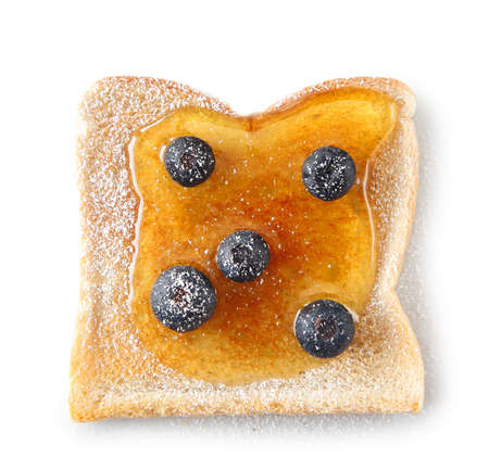 Slice of fresh white bread topped with honey and blueberries and sprinkled with sugarの写真素材