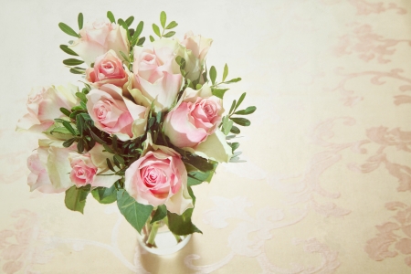 High angle view of a bunch of delicate fragrant fresh pink roses arranged in a glass vase with greenery and copyspaceの写真素材