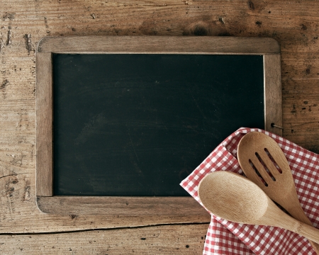Blackboard on wooden surface and serving spoonsの写真素材
