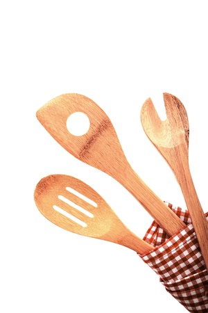 Three traditional rustic kitchen utensils in a red and white checkered cloth, isolated on white backgroundの写真素材