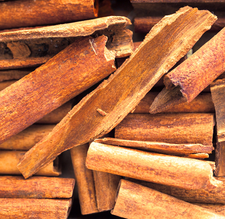 Close up background of dried stick cinnamon, a spice obtained from the inner bark of several trees from the genus Cinnamomum, used as a savoury spice and seasoning and flavouring in baking and cookingの写真素材