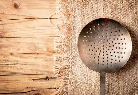 Old circular metal colander, sieve or strainer with perforated holesの写真素材