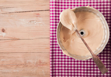 Overhead view of an old metal mould with a wooden spoonの写真素材