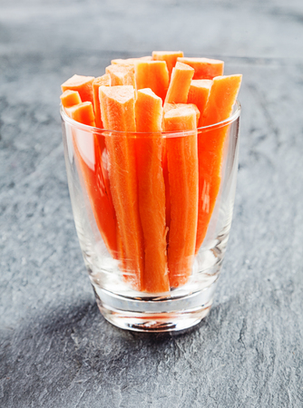 Fresh carrot batons in a glass container served as crudites on a buffet to dip in a savory sauce as a healthy appetizer to a mealの写真素材