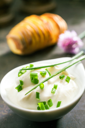 Plate of chopped fresh chives with two whole leaves ready to be used as a flavoring in salad or a garnish in cookingの写真素材