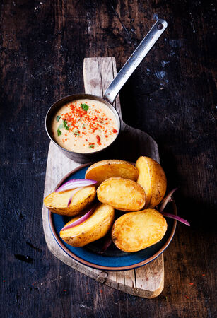 Fresh roasted potatoes garnished with cream soupの写真素材