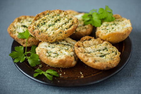Plate of grilled or toasted crispy bread seasoned with fresh herbs to serve as an accompaniment to a mealの写真素材