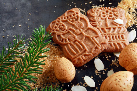 Spicy crunchy speculoos Christmas biscuits, a Dutch speciality confectionery originally baked for the feast of St Nicholas and decorated with religious patterns and pictures with almonds and fir twigの写真素材