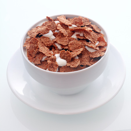 Bowl of crispy flakes of chocolate flavored breakfast cereal in milk for a tasty nutritional meal...