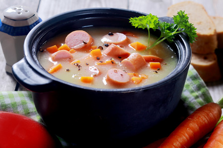 Close up Appetizing Creamy Soup Dish on Black Pot Placed on Wooden Table.の写真素材