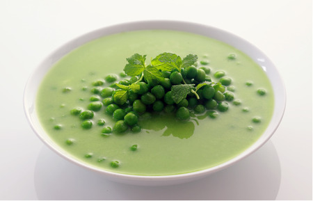 Close up Appetizing Healthy Green Peas Soup on White Bowl Isolated on White Background.の写真素材