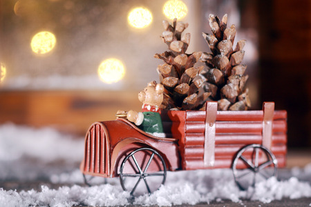 Piggy making a delivery of Xmas cones in a rustic vintage toy truck with metal spoked wheels driving...