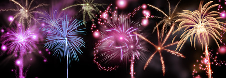 Colorful fireworks display of rockets bursting in a shower of fiery trails and sparks in a night sky...